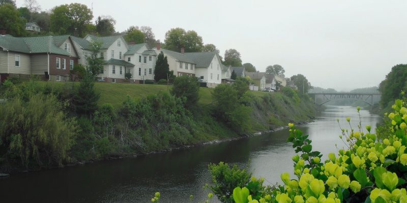 Pennsylvania riverside town with houses stepping up a hillside above a slow green river