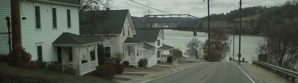 Small Pennsylvania river borough with tidy porched houses sloping toward a steel truss bridge